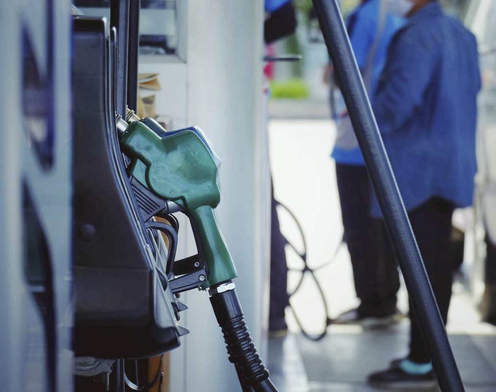Abastecer o Carro e Recobrar as Energias. Homens ao lado de bombas de gasolina