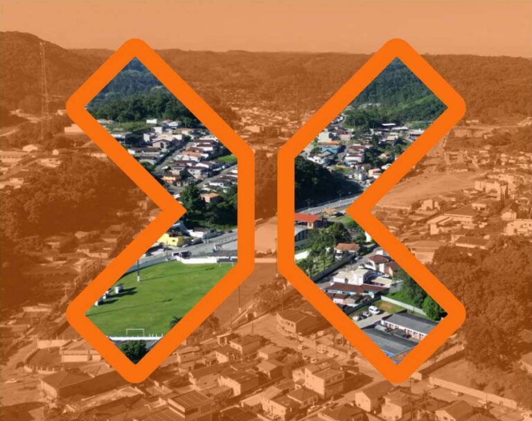 Vista aerea da cidade alaranjada com visão nítida somente dentro do grande X do logotipo da TRIX vazado.
