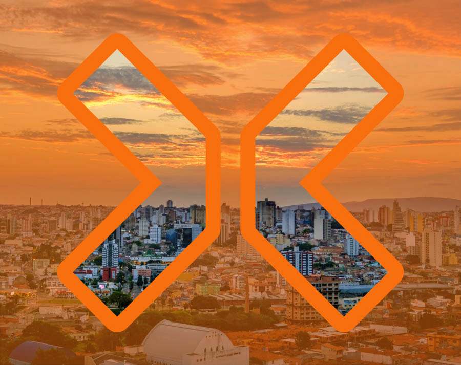 Vista aerea da cidade alaranjada com visão nítida somente dentro do grande X do logotipo da TRIX vazado.